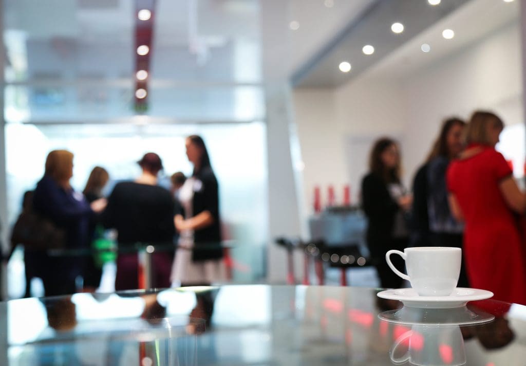 Seminar-Szene mit Menschen im Hintergrund und Kaffeetasse vorne, Foto: Pixabay, Cozendo
