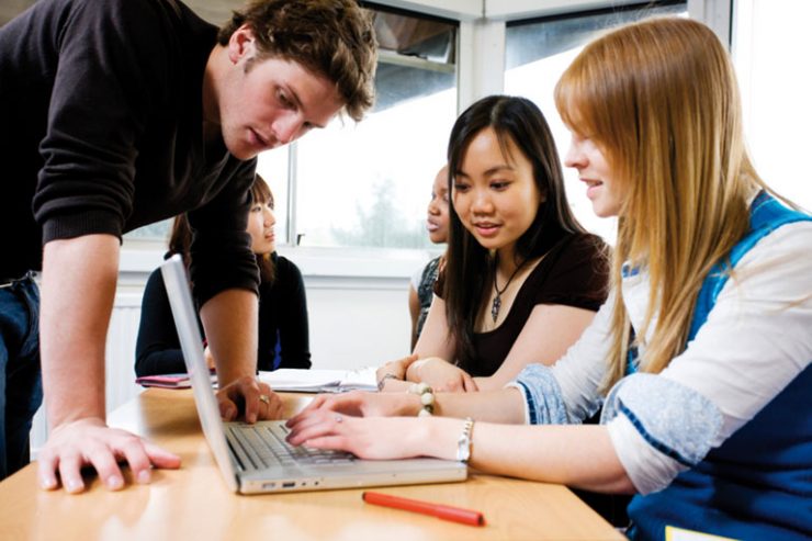 lehrer hilft studierenden am laptop, foto: istock, urbancow