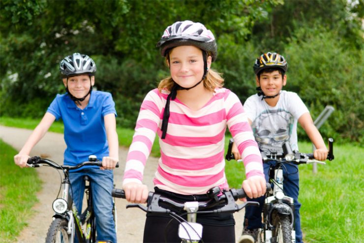 drei kinder auf dem fahrrad mit helm, foto: fotolia, racle fotodesign