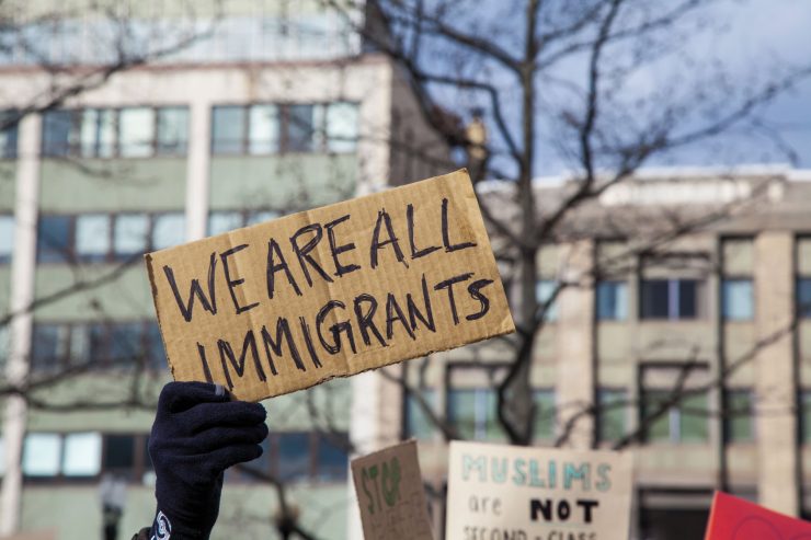 pappschild we are all immigrants vor gebaeude, foto: fotolia, jp photography