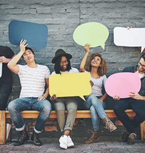 gruppe junger leute sitzend mit sprechblasen in den haenden, foto: istock, peopleimages