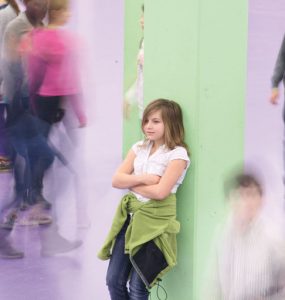 thema mobbing - maedchen steht isoliert am dem schulhof, foto: referat fuer bildung und sport