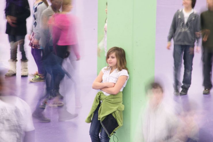 thema mobbing - maedchen steht isoliert am dem schulhof, foto: referat fuer bildung und sport