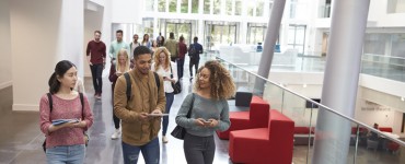 Junge Studierende laufen durch Universitätsgebäude, iStock, monkeybusiness