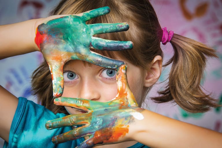 Mädchen schaut durch Farbhände, Foto: Fotolia, Vera Kuttelvaserova