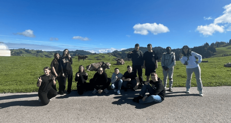 Gruppe von Jugendlichen mit Begleitperson vor Bergkulisse