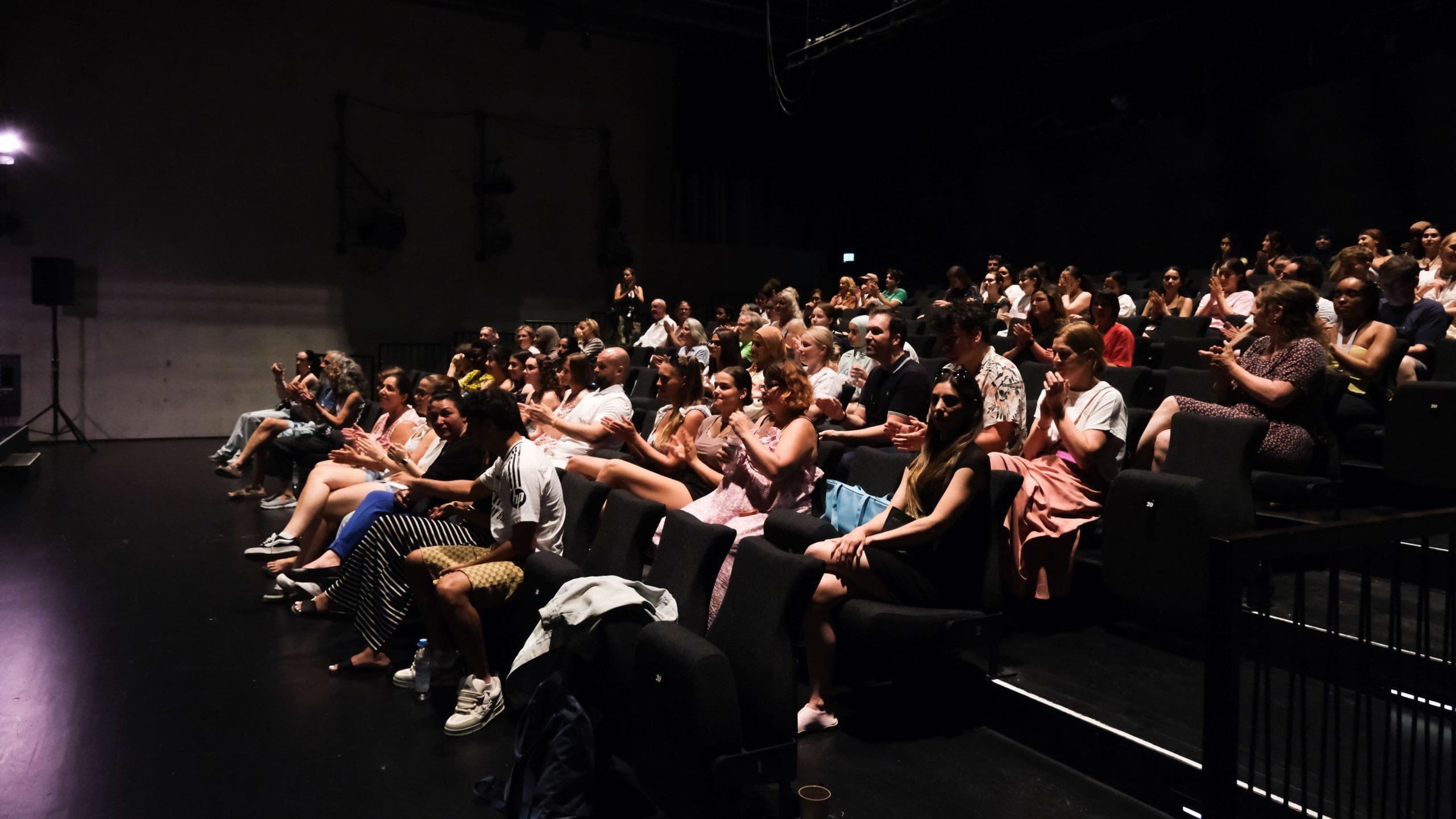 Das Publikum des Kulturfestivals #ActNow sitzt im Zuschauerraum des Volkstheaters und applaudiert.
