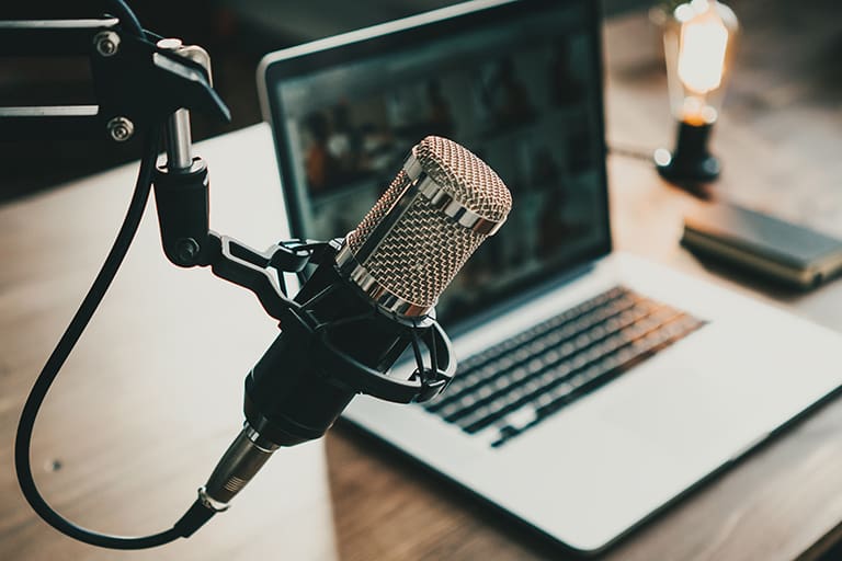 Innenansicht eines Heimstudio-Podcasts. Mikrofon, Laptop und „On-Air“-Lampe auf dem Tisch, Nahaufnahme, Foto: Adobe Stock, Alex from the Rock